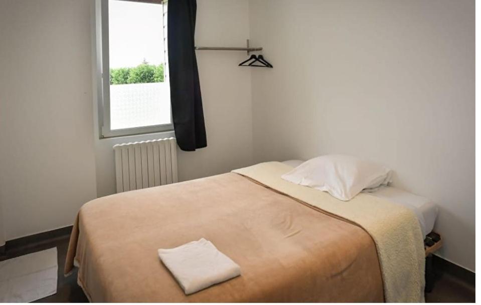 a small bedroom with a bed with a window at La Halte in Torigni-sur-Vire