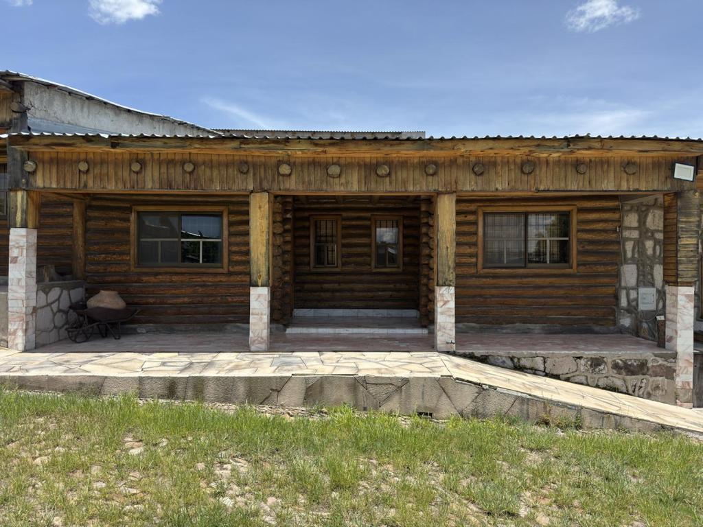 a log home with a large porch and a patio at Hotel Nuevo Barrancas del Cobre in Creel