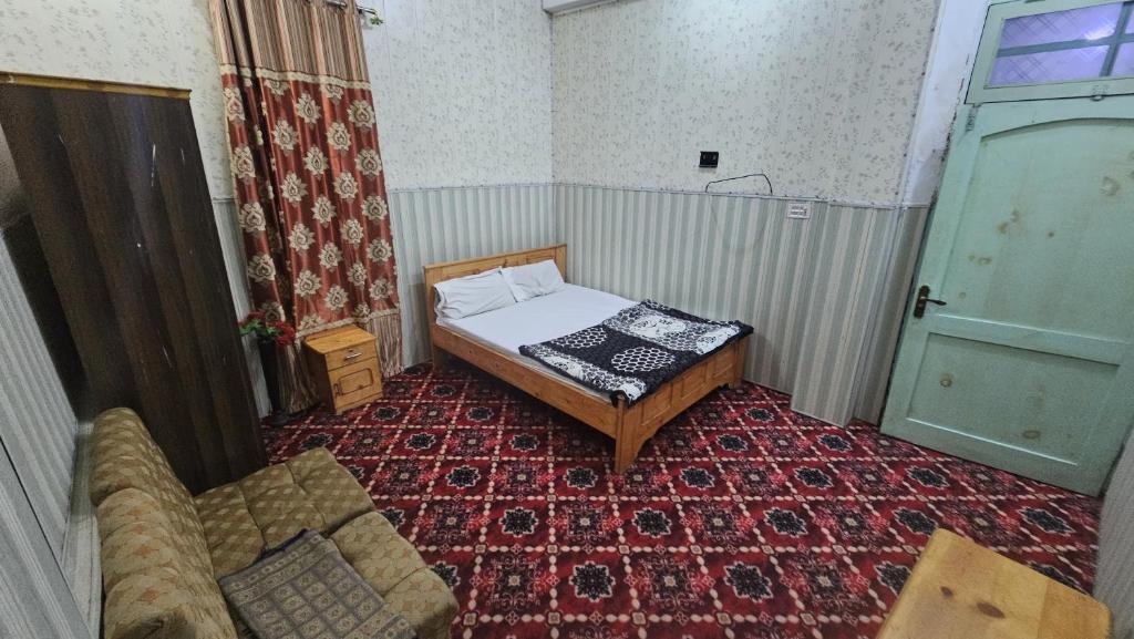 a small room with a bed and a couch at Galiyat City hotel in Mingāora