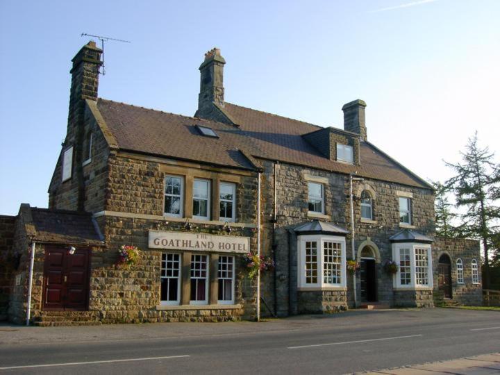 an old stone building on the side of a street at The Goathland Hotel in Goathland