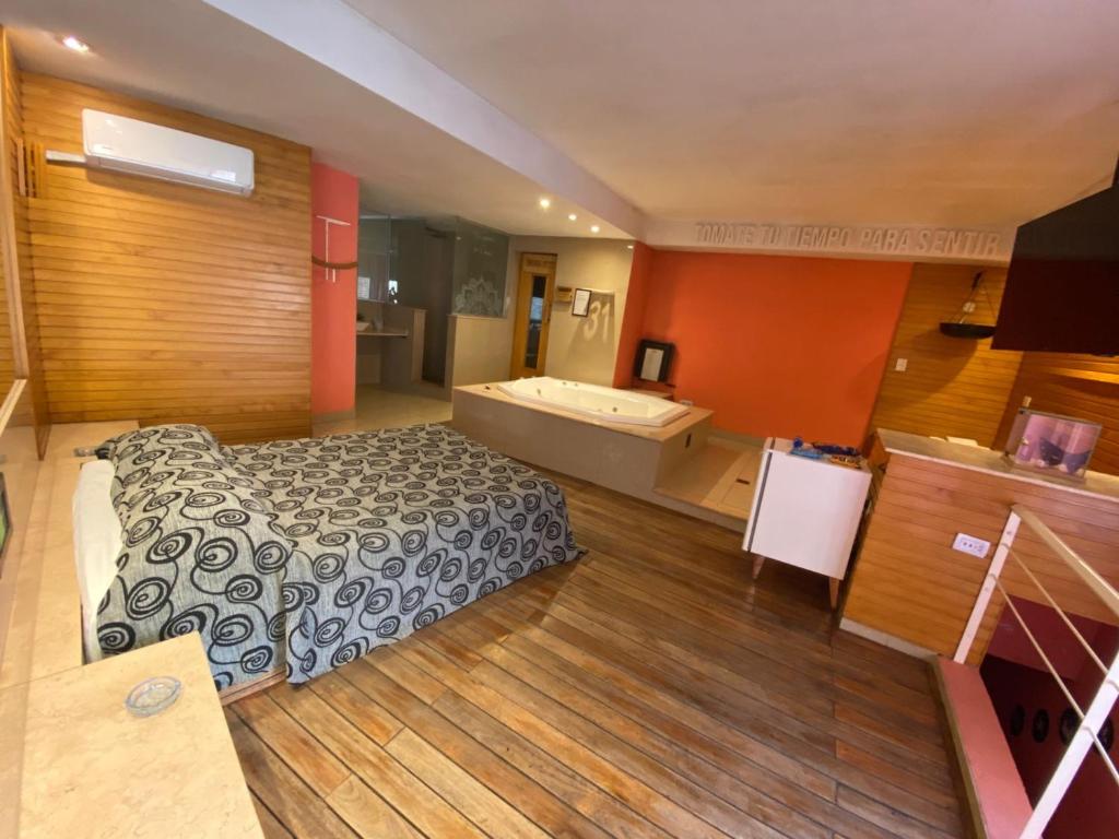 a hotel room with a bed and a bath tub at Hotel Lido in General Rodríguez