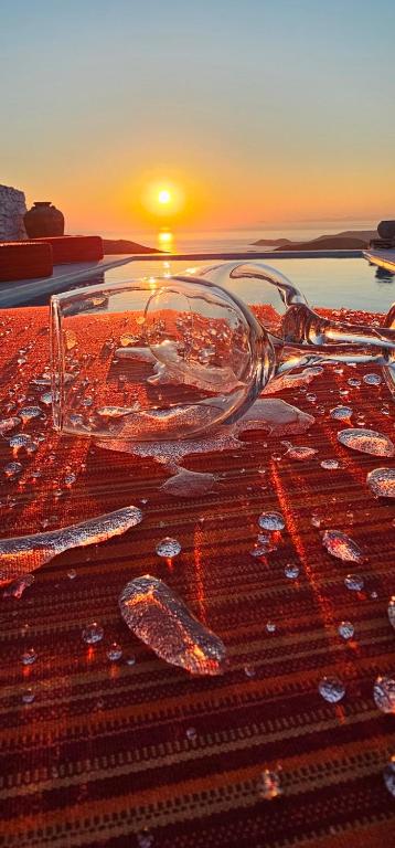 a glass jar on a table with the sunset in the background at 3 SENSES villa in Dhriopís