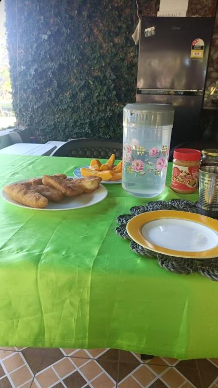 a table with a green table cloth with a plate of food at Navi Homestay in Naisisili