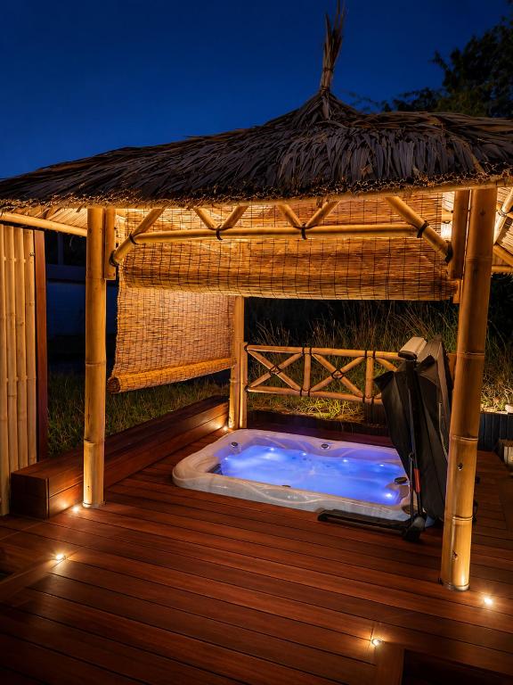 a hot tub under a gazebo at night at ZenArden - Ninglinspo Valley View & Private Spa in Aywaille