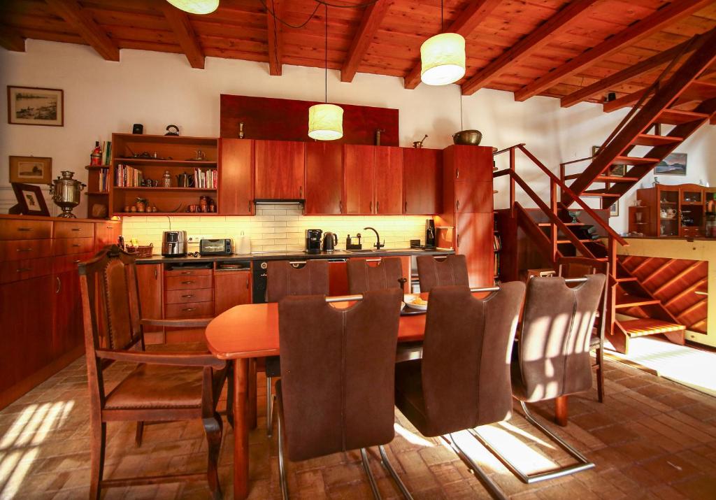 a kitchen with a table and chairs and a staircase at Bambuszkert in Kisoroszi