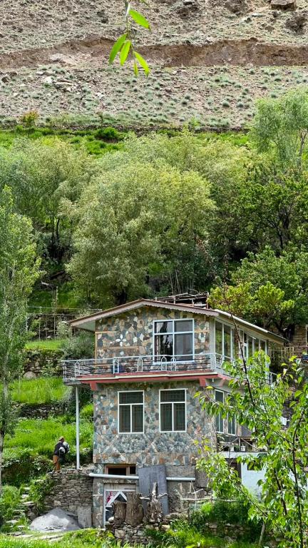 a stone house sitting on the side of a hill at Bagh Rustum Guest House in Holshāl