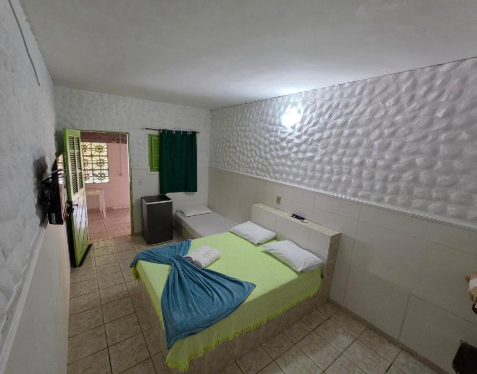 a small bedroom with a bed and a bathroom at Pousada Golfinho in Galinhos