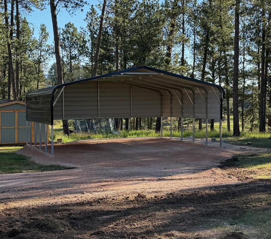 a large metal pavilion in the middle of a dirt road at Custer Love Shack in Custer