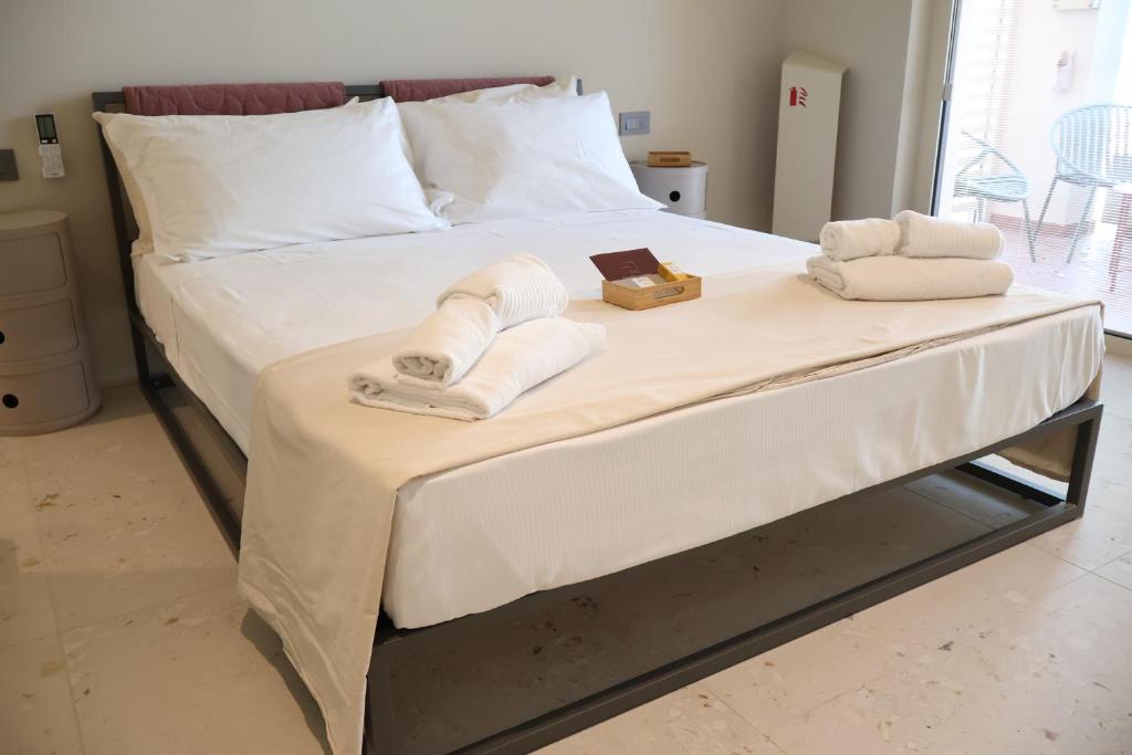 a bed with two towels and a tray of towels at Lumiére Marine in Roseto degli Abruzzi