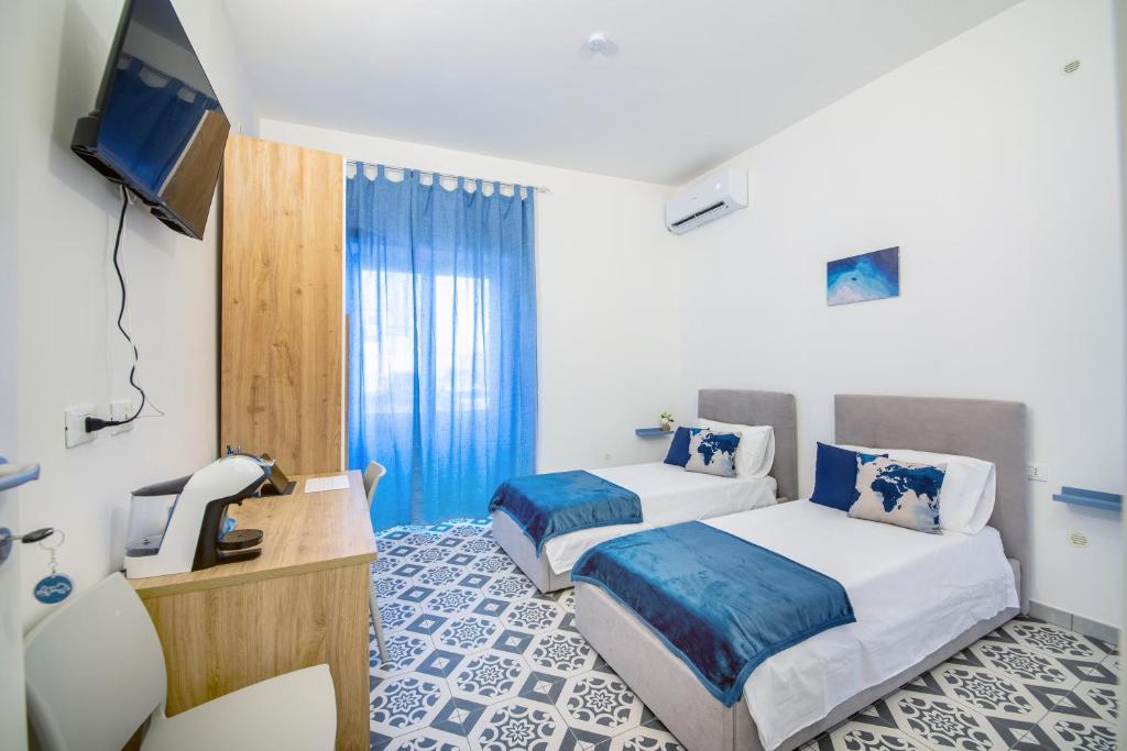 a hotel room with two beds and a television at Casa iSuLa in Iglesias