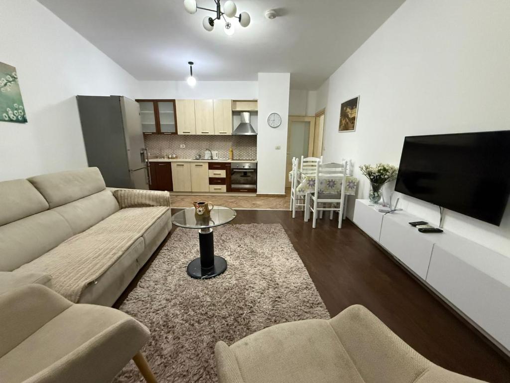 a living room with a couch and a flat screen tv at REA Apartment in Shkodër