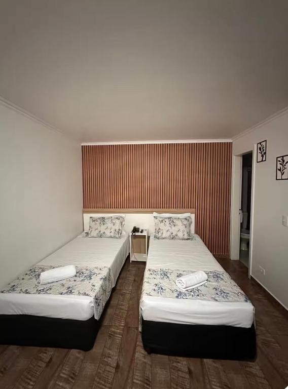a room with two beds in a room at Flat no centro de Curitiba in Curitiba