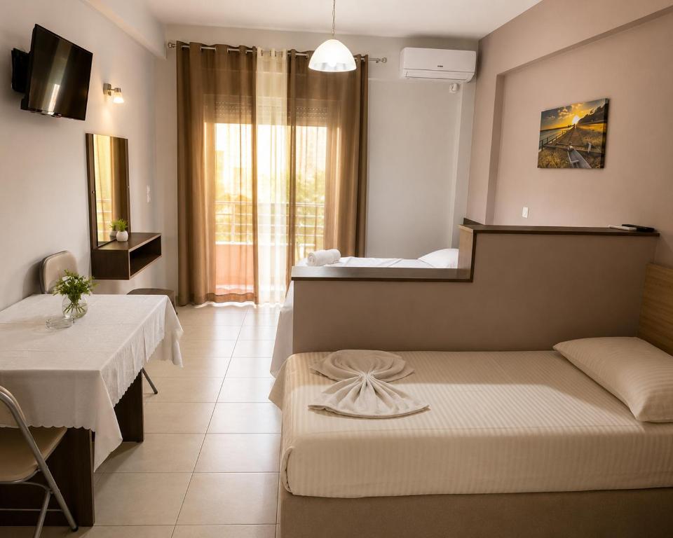 a bedroom with a bed and a table and a mirror at Studio Beleri in Himare