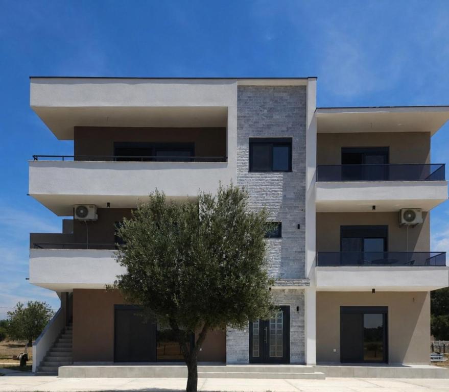 a building with a tree in front of it at Apartman 2 in Gornji Štoj