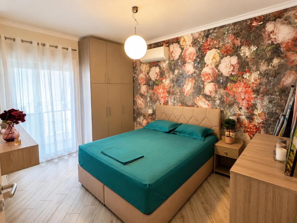 a bedroom with a bed and a floral wall at Luxury & Modern Apartment in Paralia Katerinis
