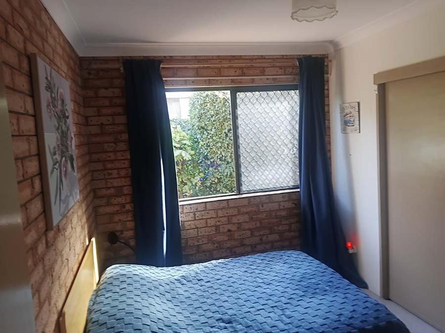 a bedroom with a blue bed and a window at Connies Retreat in Gold Coast