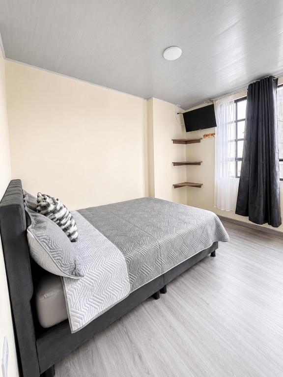 a bedroom with a bed and a television in it at Hotel Casa Mónaco Tunja in Tunja