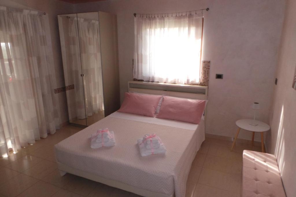a bedroom with a bed with two pairs of shoes on it at La casa di Mazzancollo in San Martino in Pensilis