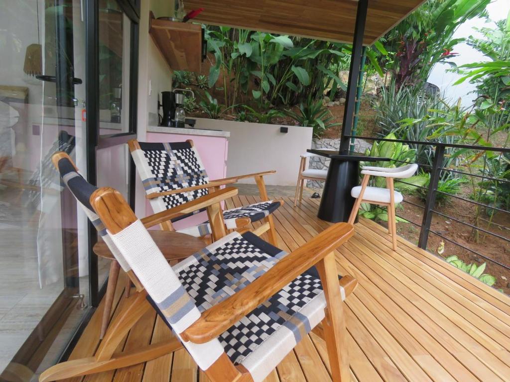 a group of chairs sitting on a porch at Ruca Lodge -Luxury Cabins Nestled in Nature in Uvita
