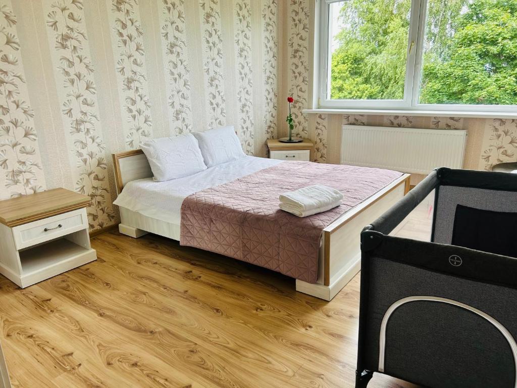 a bedroom with a bed and a window and a chair at Levandų šeimyniniai apartamentai su vonia ir sodu in Ryškėnai