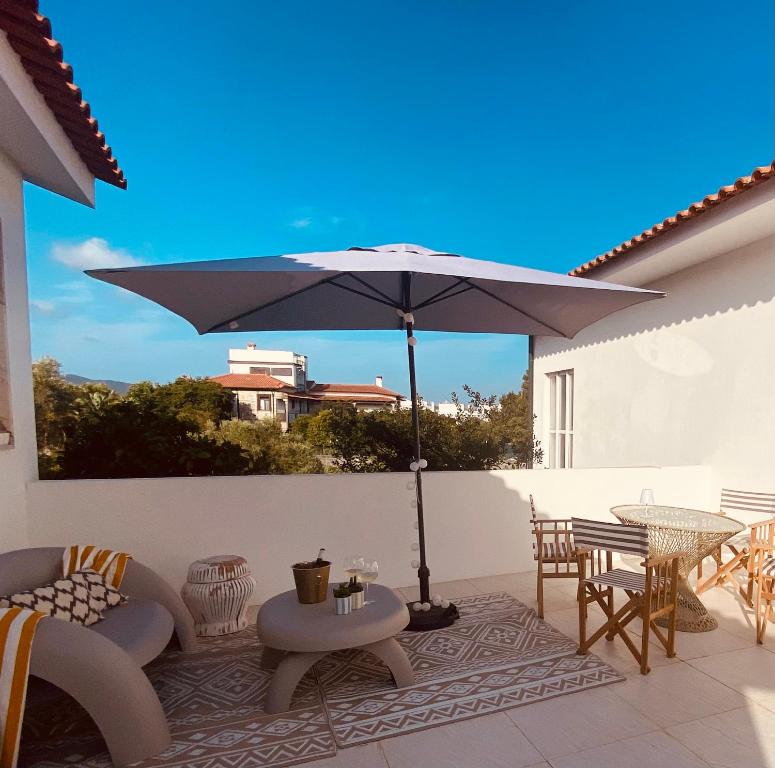 a patio with an umbrella and a table and chairs at Casa da Âncora in Viana do Castelo