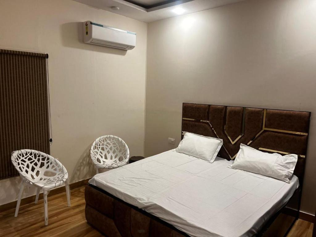 a bedroom with a bed and two chairs at Luxe Farm in Greater Noida