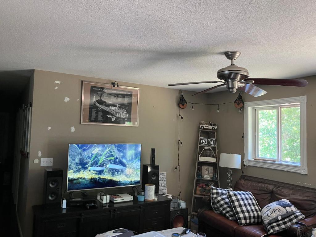 a living room with a ceiling fan and a television at Philomath place in Philomath