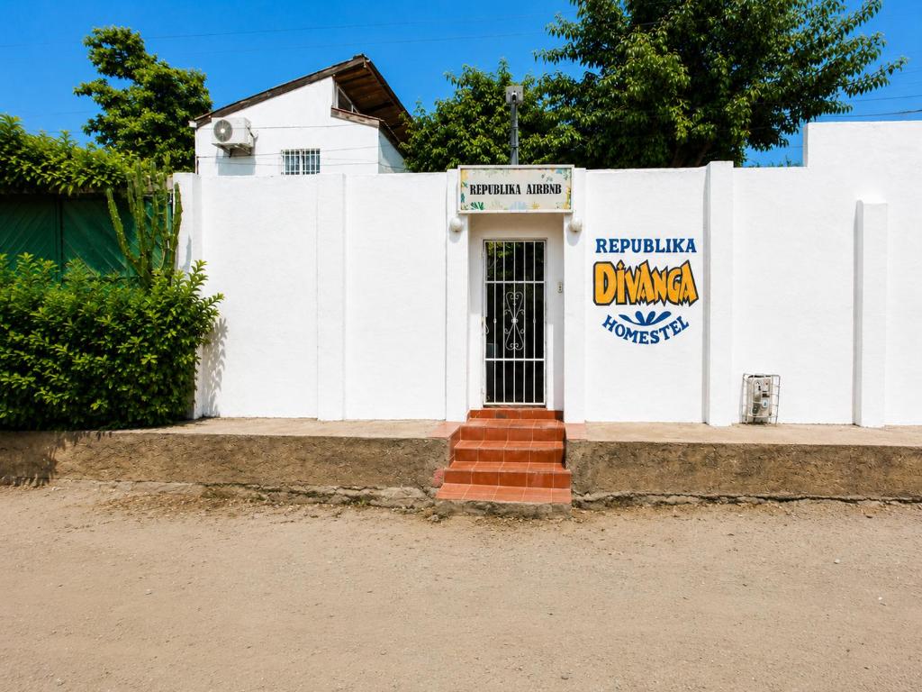 a white building with a sign on it at Republika Divanga Homestel in Taganga