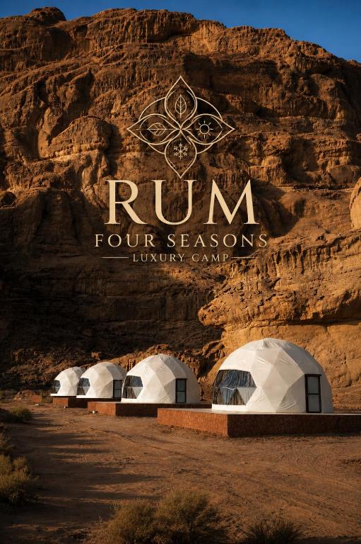 a group of four seasons tents in front of a mountain at Rum Four Seasons luxury Camp & Jeep Tours in Wadi Rum