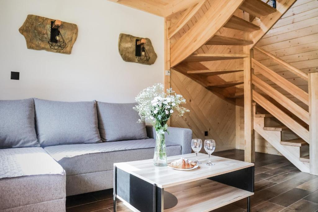 a living room with a couch and a table with wine glasses at Domek Za Dworem in Witów