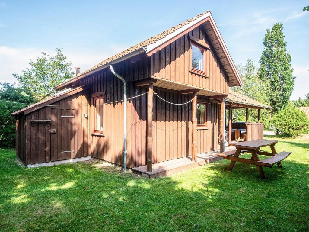 a wooden cabin with a picnic table in the grass at 8 person holiday home in Hovborg-By Traum in Hovborg