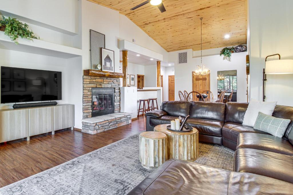 a living room with a leather couch and a fireplace at Hot Tub, Deck & Grill! Mtn Retreat in Show Low in Show Low