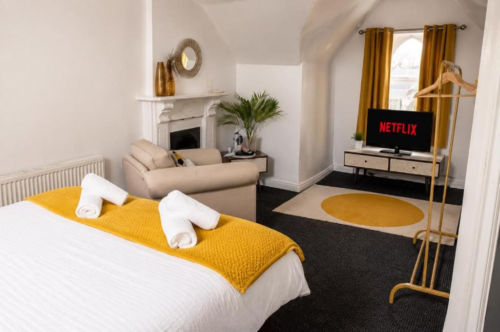 a bedroom with a bed and a living room with a tv at Spacious Large Group House Near NEC and Airport in Birmingham
