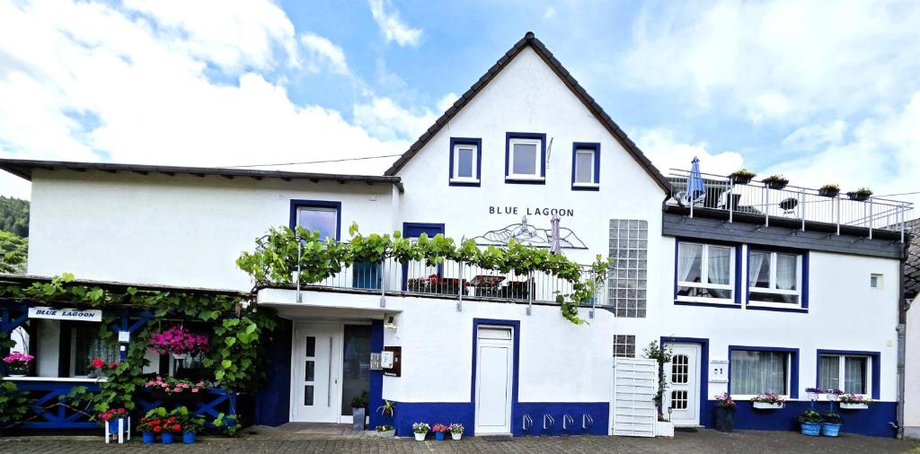 a white house with a balcony with plants at Blue Lagoon Holiday Apartments & Double Room with Balcony in Nehren