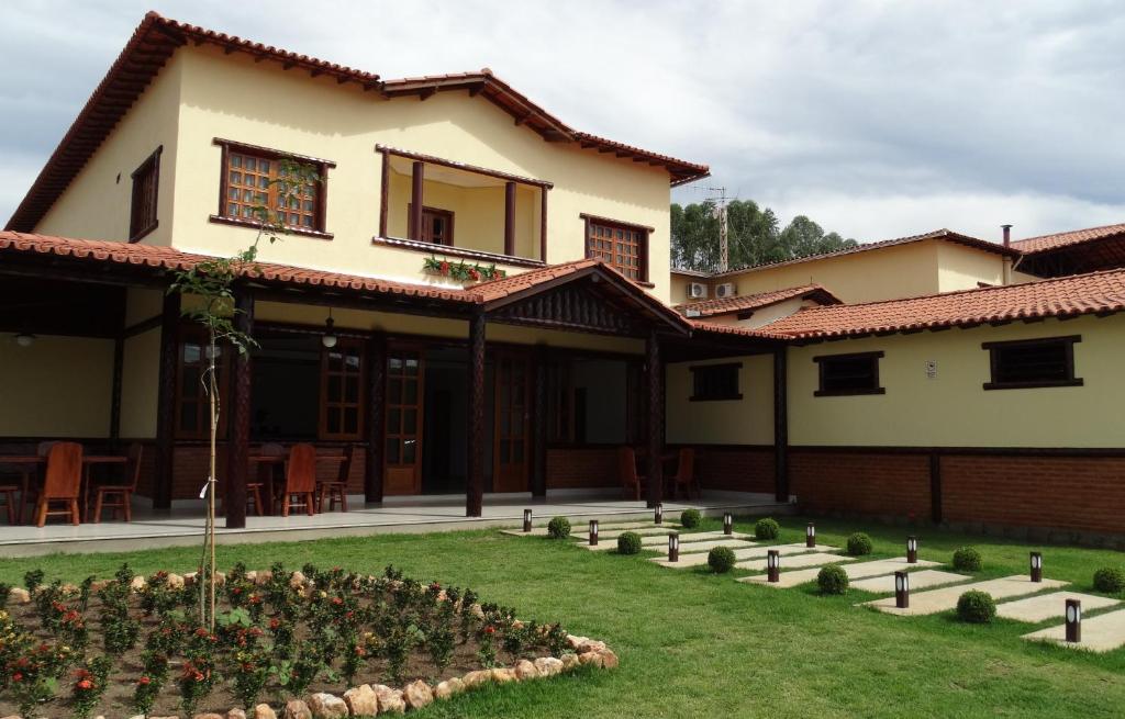 a house with a garden in front of it at Hotel e Restaurante Sabor de Minas in Salinas