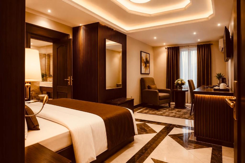 a hotel room with a bed and a desk at E-Luxe Suites Hotel in Abuja