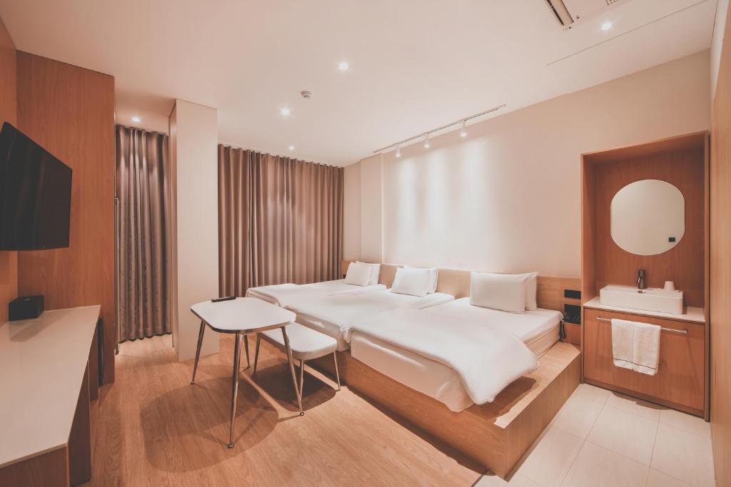 a bedroom with a large white bed and a sink at 호텔 인썸니아 Hotel Insomnia 失眠酒店 in Daegu
