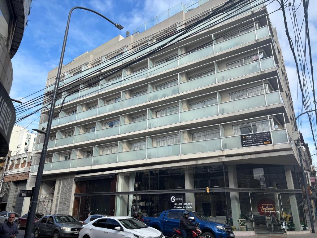 a building on a street with cars parked in front of it at Modern and Warm Apartment in Buenos Aires