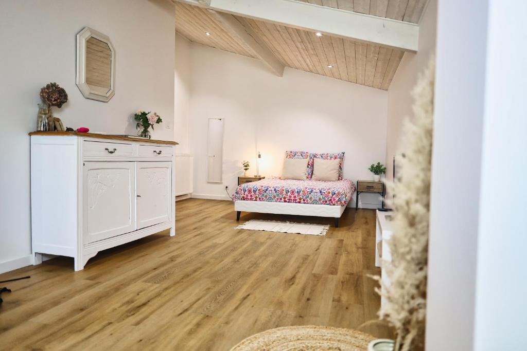 a living room with a couch and wooden floors at Chambre d'hôtes Château Austerlitz in Libourne