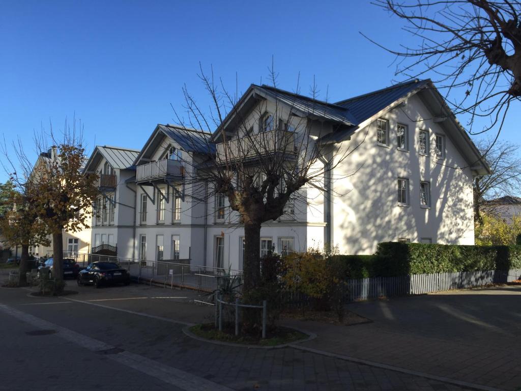 a white house with a tree in front of it at Villa Am Strand - Neubau in Ahlbeck