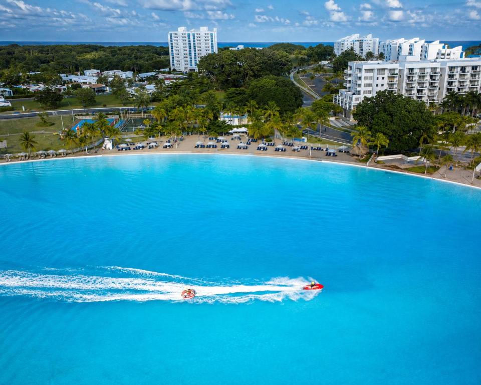 a boat in the water in front of a beach at Blue Diamond Suite de playa in Playa Blanca