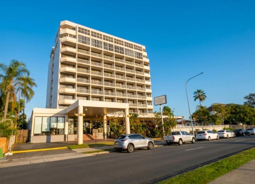 ein großes Gebäude, vor dem Autos parken in der Unterkunft The Oceanfront in Cairns