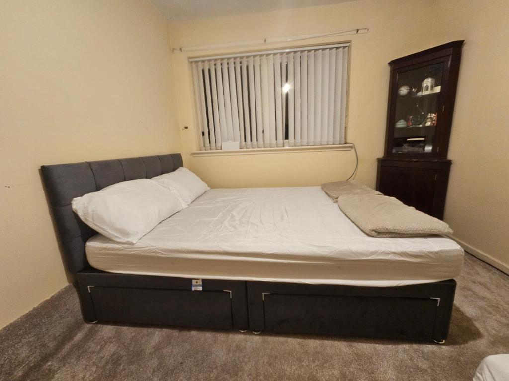 a small bed in a room with a window at Nad's Guest house in Motherwell