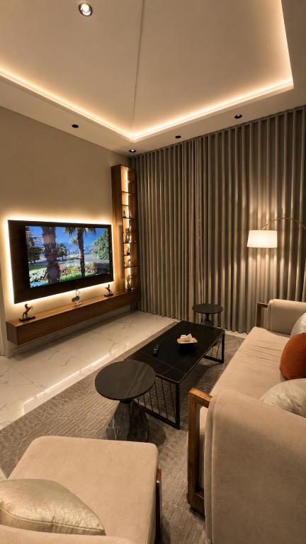 a living room with a couch and a flat screen tv at شقة واسعة وانيقة in Hail