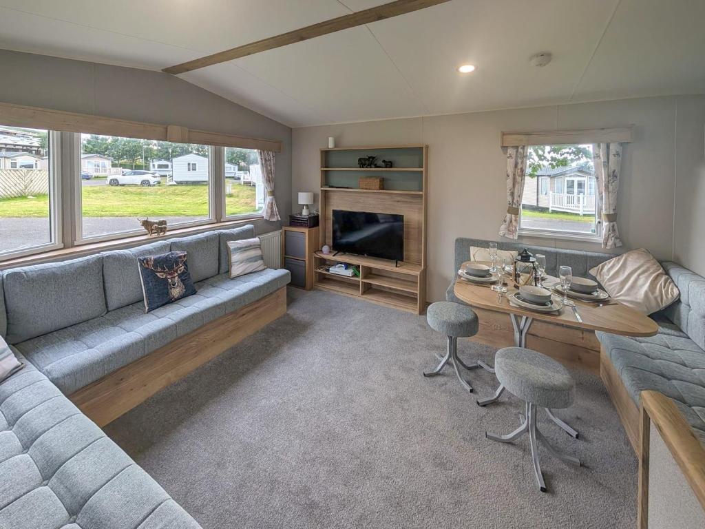 a living room with a couch and a table at Kjs Holiday Haven in Ayr