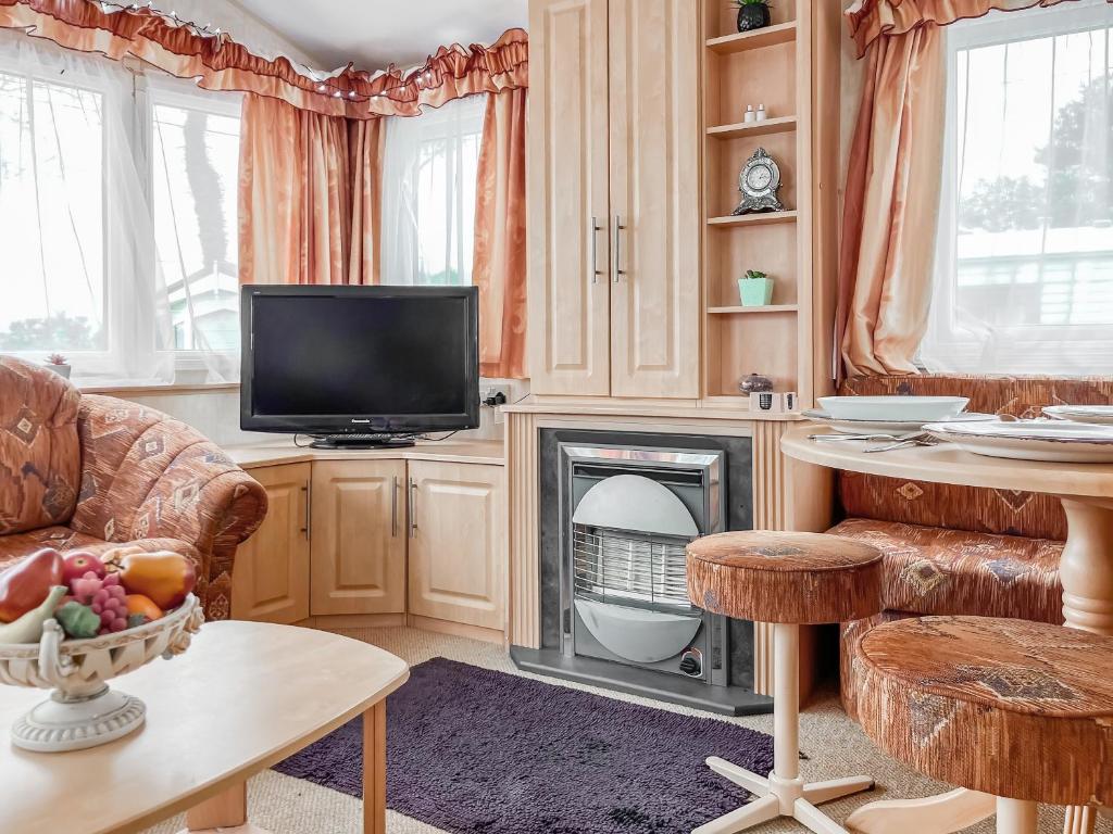a living room with a television and a fireplace at Oakmere - Uk51989 in Oakmere