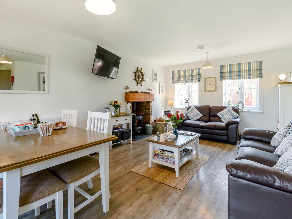 a living room with a couch and a table at The Bay - The Bolthole in Reighton