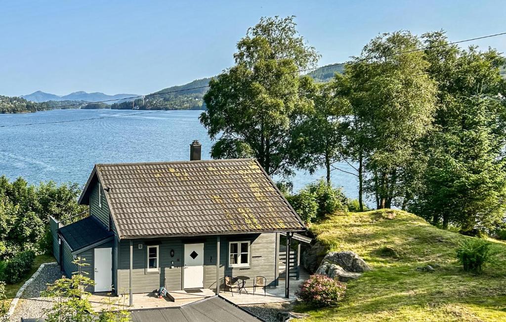 a small house on a hill next to the water at Stunning Home In Seim With Wifi in Seim