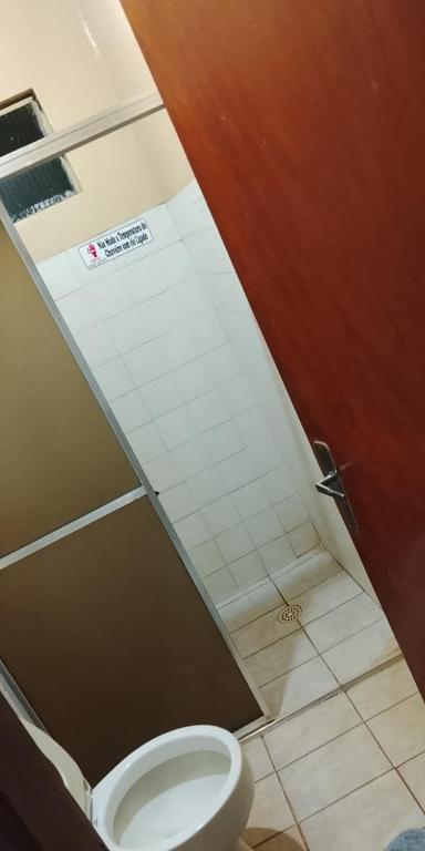 a bathroom with a white toilet in a stall at Hotel 3 Reis in Guia Lopes da Laguna