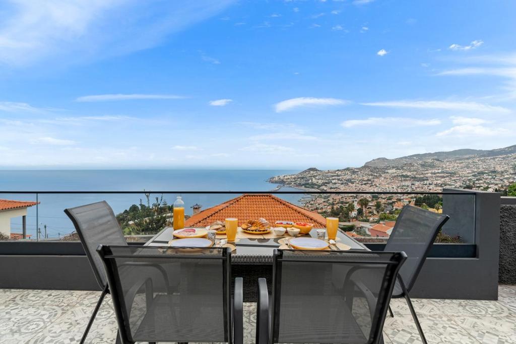 a dining table with a view of the ocean at Casa Afonso Bay Views & Outdoor Living in Funchal